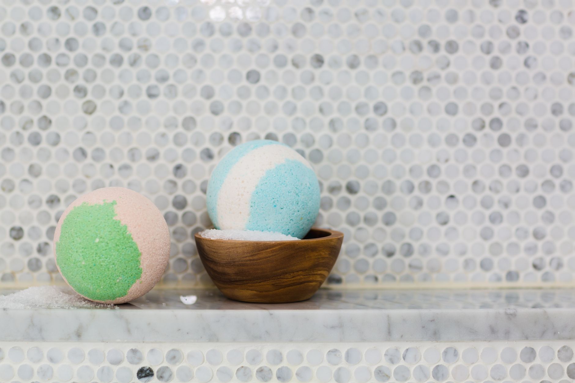 Colorful pastel bath bombs displayed on a marble surface for spa ambiance.