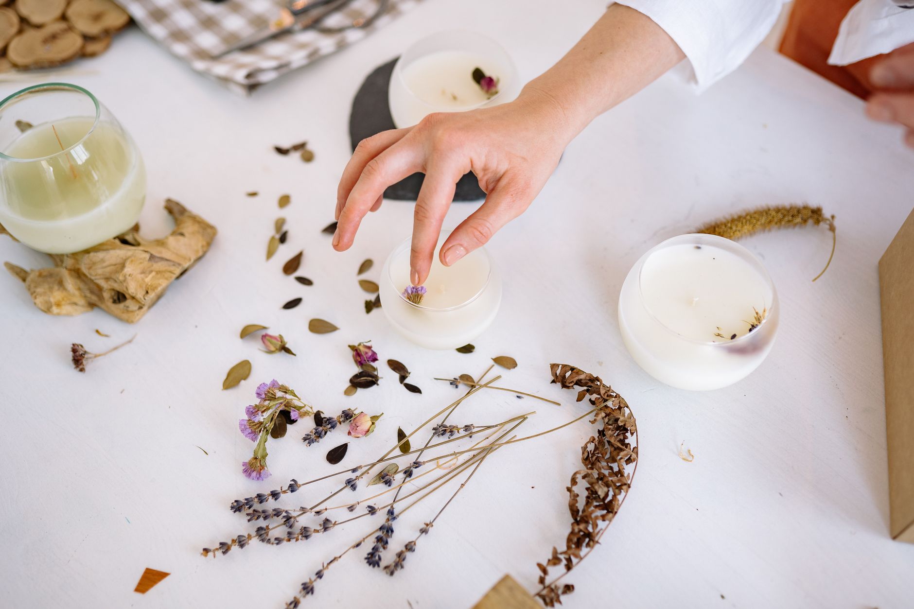 Creating handmade candles with dried flowers and leaves for unique decorations.