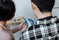 aap-how-to-make-resin-jewelry-for-beginners-1790873911 A couple examines a handmade blue resin art coaster in an indoor setting.
