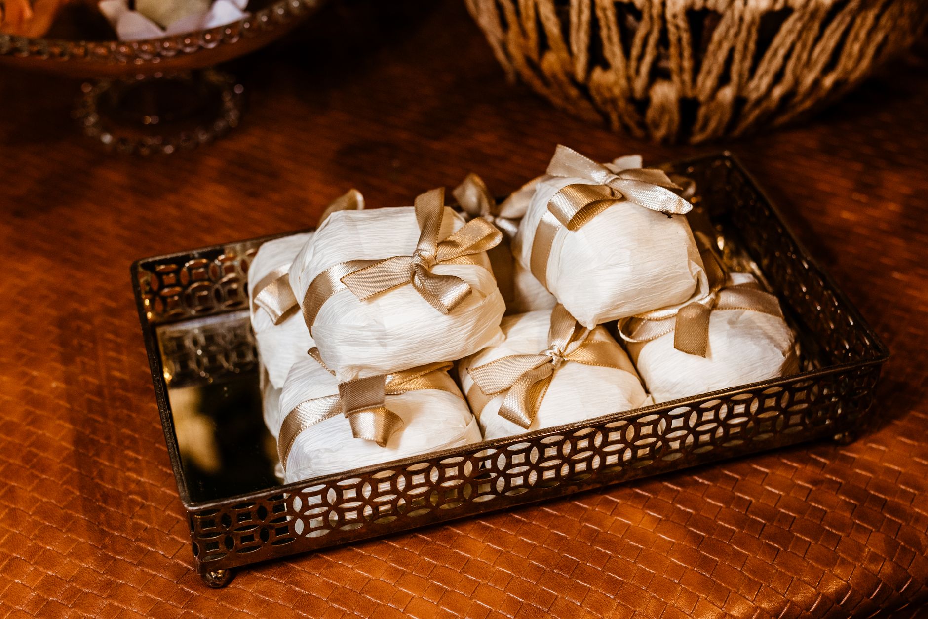A collection of meticulously wrapped gifts with gold ribbons displayed on a decorative metallic tray.